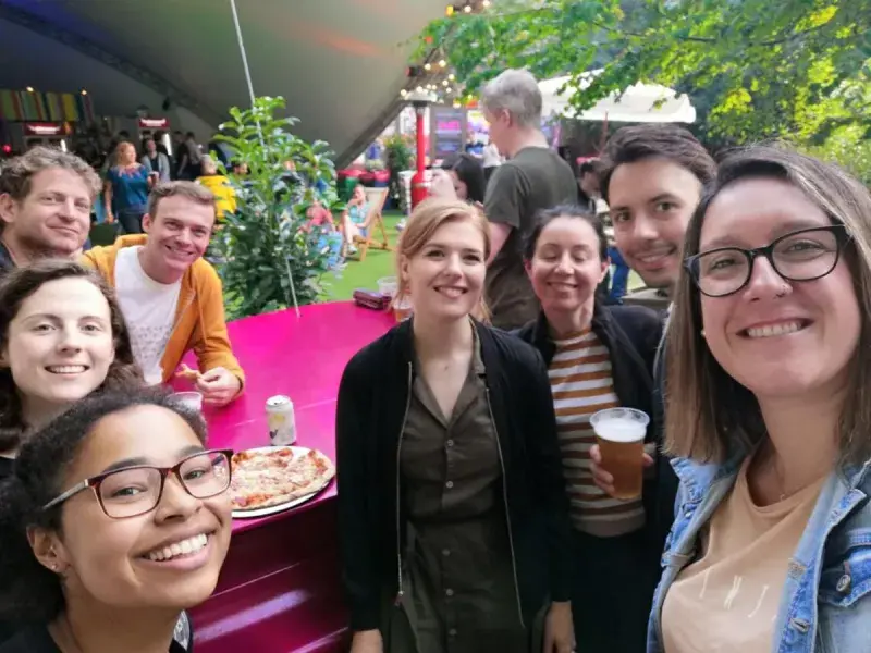 Group members from van Ooijen lab at the Fringe festival standing by a table outdoors with food and drinks