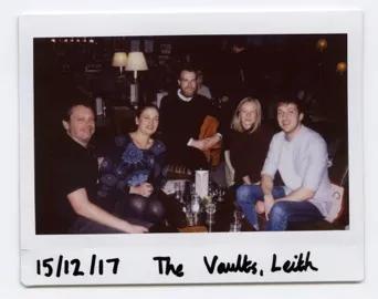 Photo of the lab group member, seated and gathered around a table in the vaults, Leith