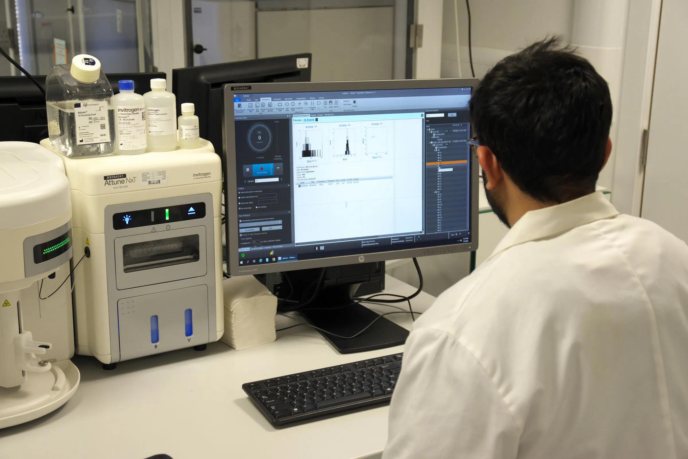 Scientist sitting at an Attune flow cytometer