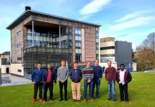 Members of the lab group standing outside the King's Buildings Library on a sunny day.