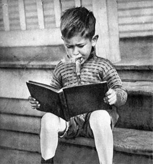 A child reading a book while smoking a cigar.
