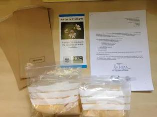 Photo of the collecting kit contents; collection notes, 20 silica bags, seed envelopes and return postage