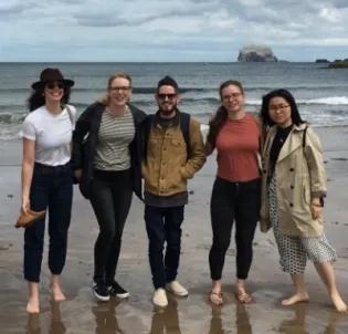 Photo of 5 lab group members posed fr a photo in front of the sea, Bass rock in the background