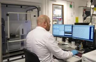 A scientist sitting at a FACS Aria III cell sorter