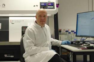 Christopher Hall sitting at an S8 flow cytometer 