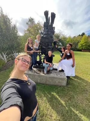 Photo of students gathered around a statue outside