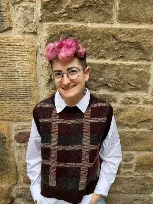 Image of Mash wearing glasses with short bright pink hair