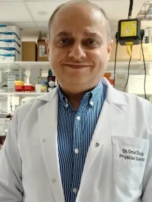 Photo of Onur Duygu in a lab coat