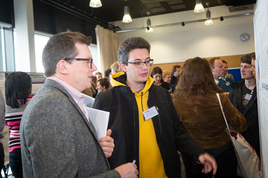 Phot of supervisors and students at a Poster session, 2019 Symposium