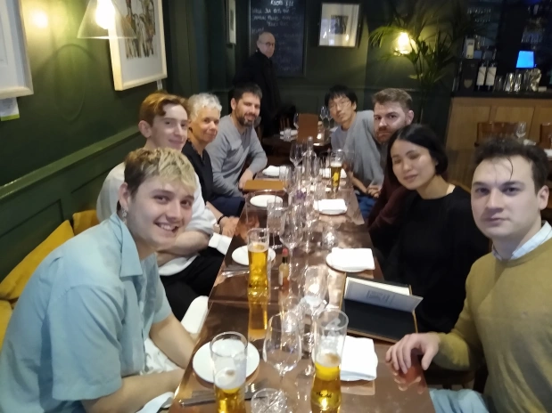 Group photo of all the lab members sitting at a table in a restaurant