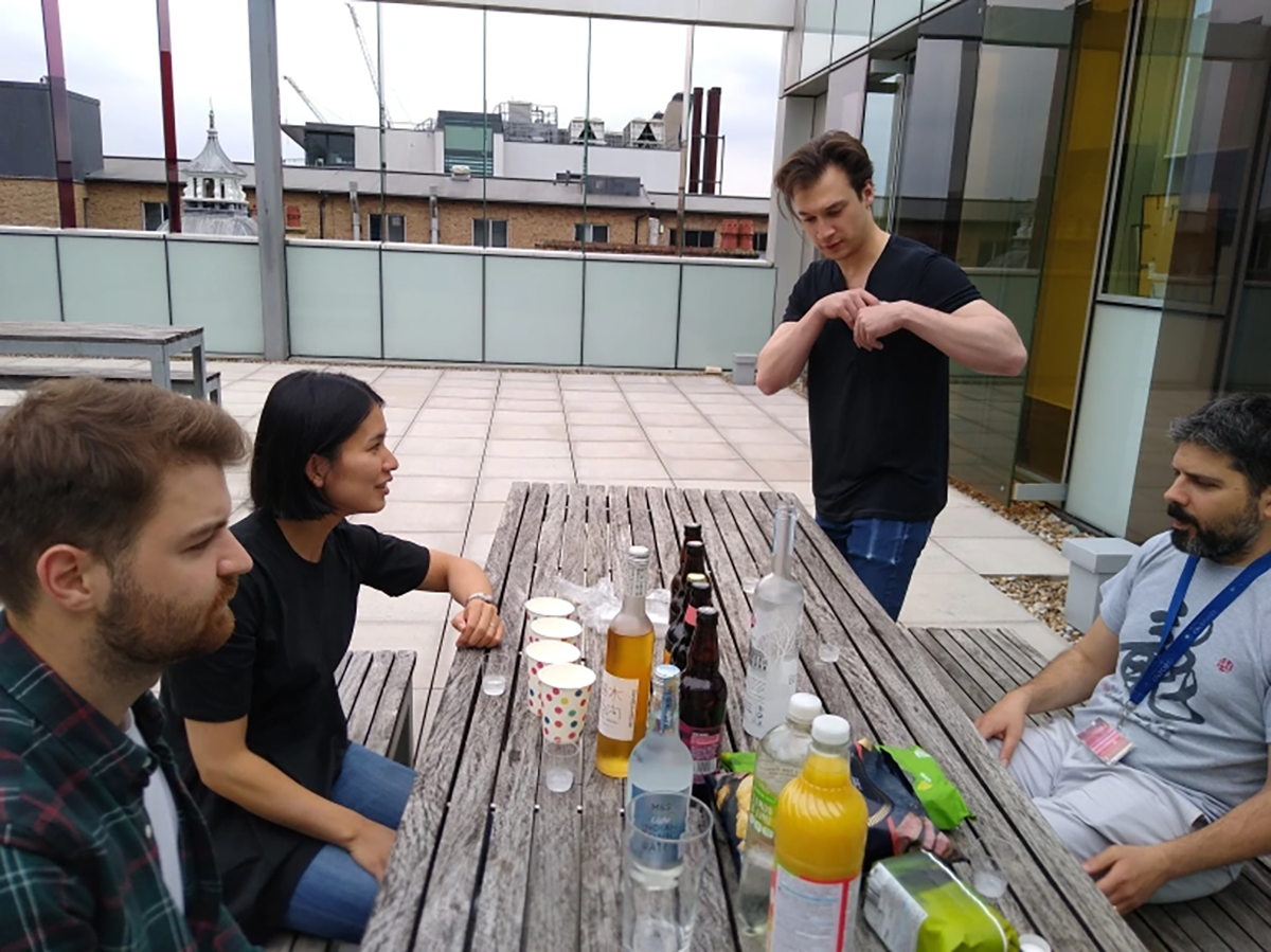 Photo of the lab group seated at a table outside a building