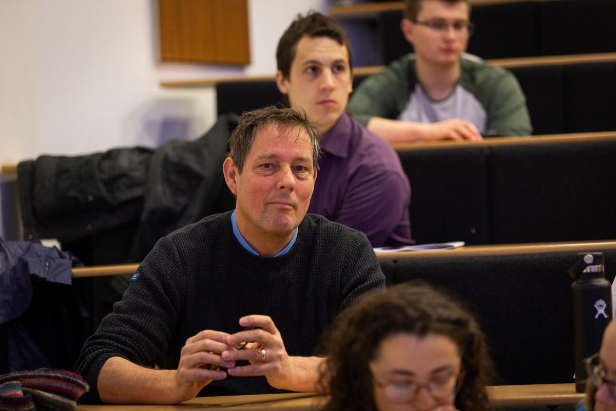 People sitting in lecture theatre watch a presentation