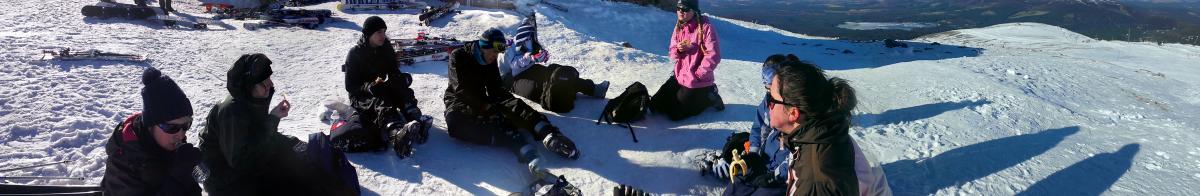 Panorama photo of the group sitting around on the snow