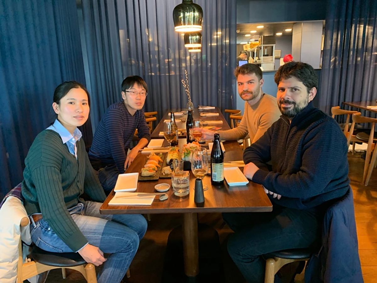 Group photo of lab members sat around a restaurant table