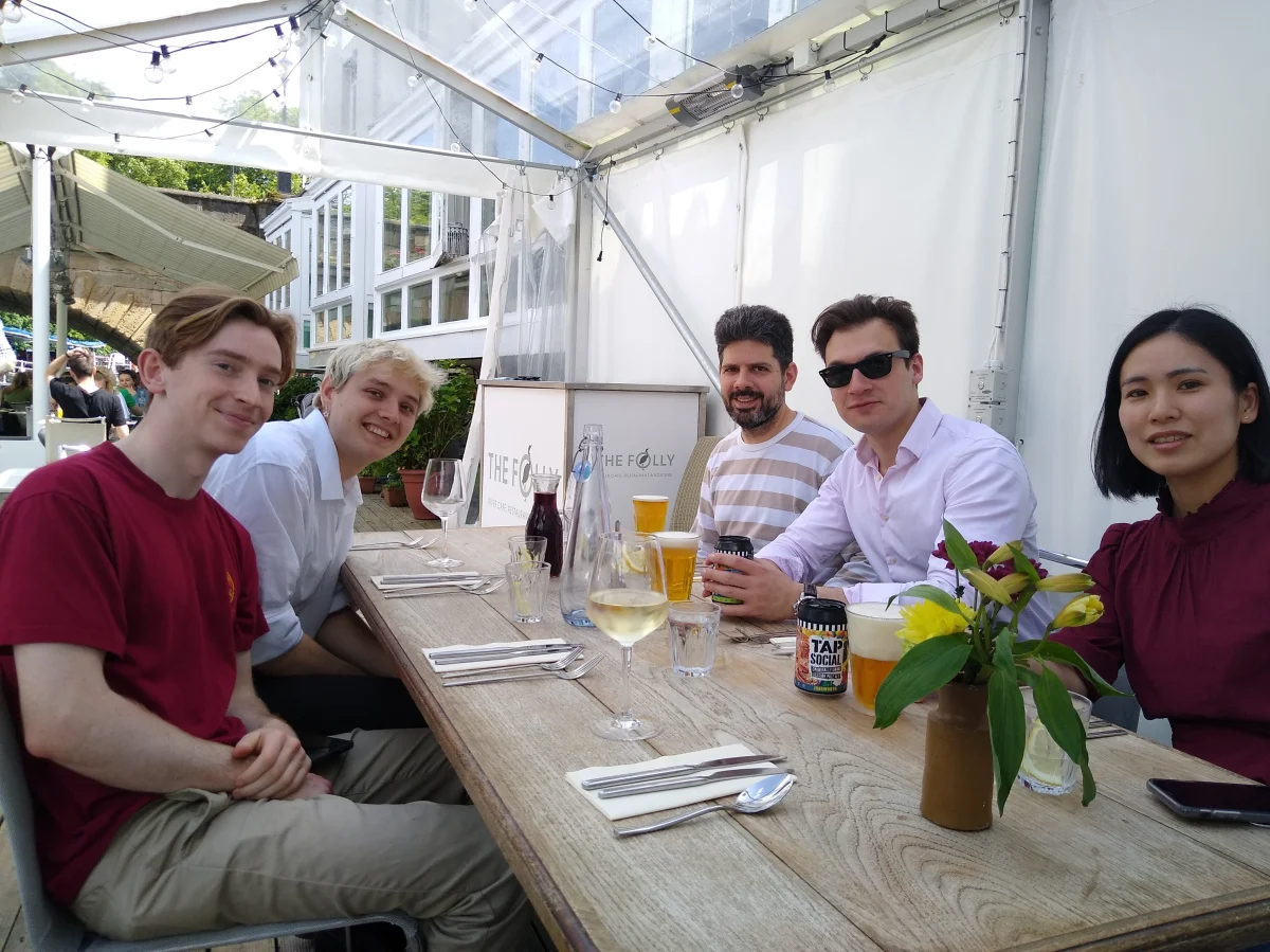 Group photo with the lab members sitting around a table