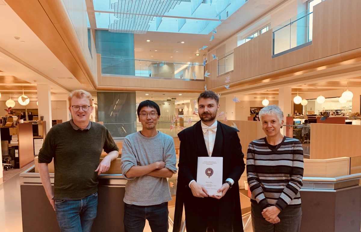 Patryk Ludzia with his certificate, the two examiners and Bungo