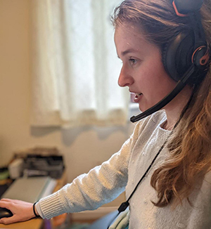 Photo of Laurine at a desk wearing a headset