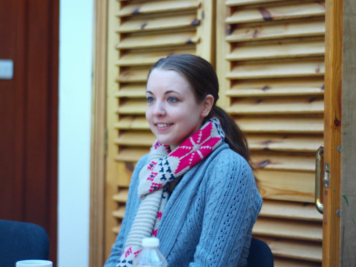 A lab member sitting indoors wearing a colourful winter scarf