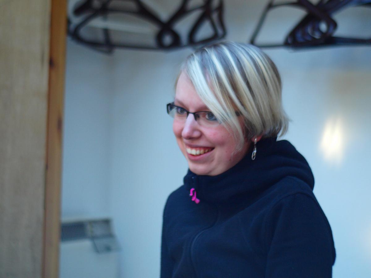 A lab member wearing ski jacket indoors, smiling