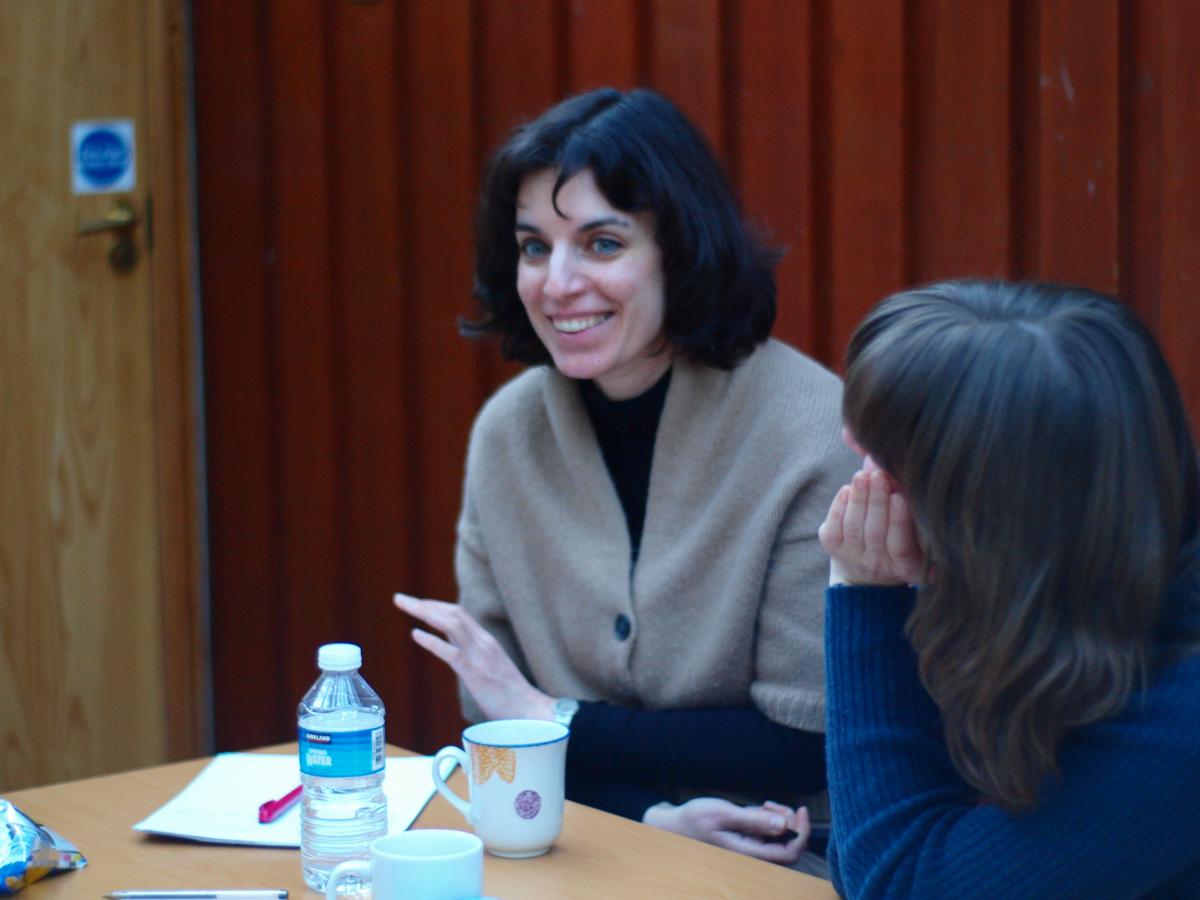 Two lab members sit side by side and share a laugh