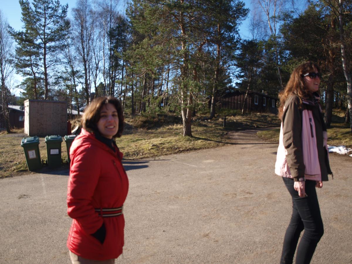 A lab mebers smiles and looks at the camera whilst walking on a track near trees 