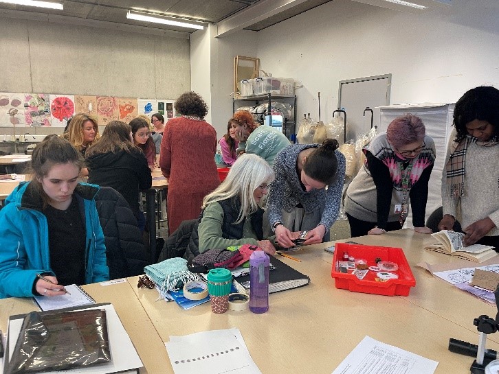 College students and researchers gather round desks and examine materials used in the public engagement event