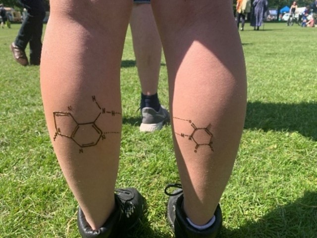 Photo of a person's calves, tattooed with DNA helix henna design