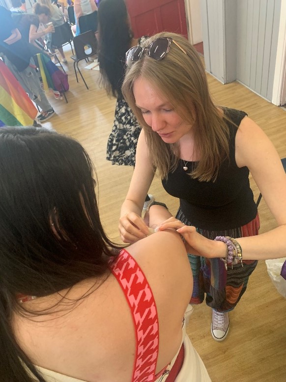 A researcher applies a temporary tattoo to a member of the public's arm. 