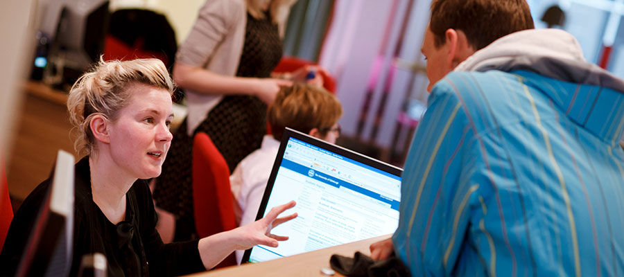 Photo of support staff helping a student