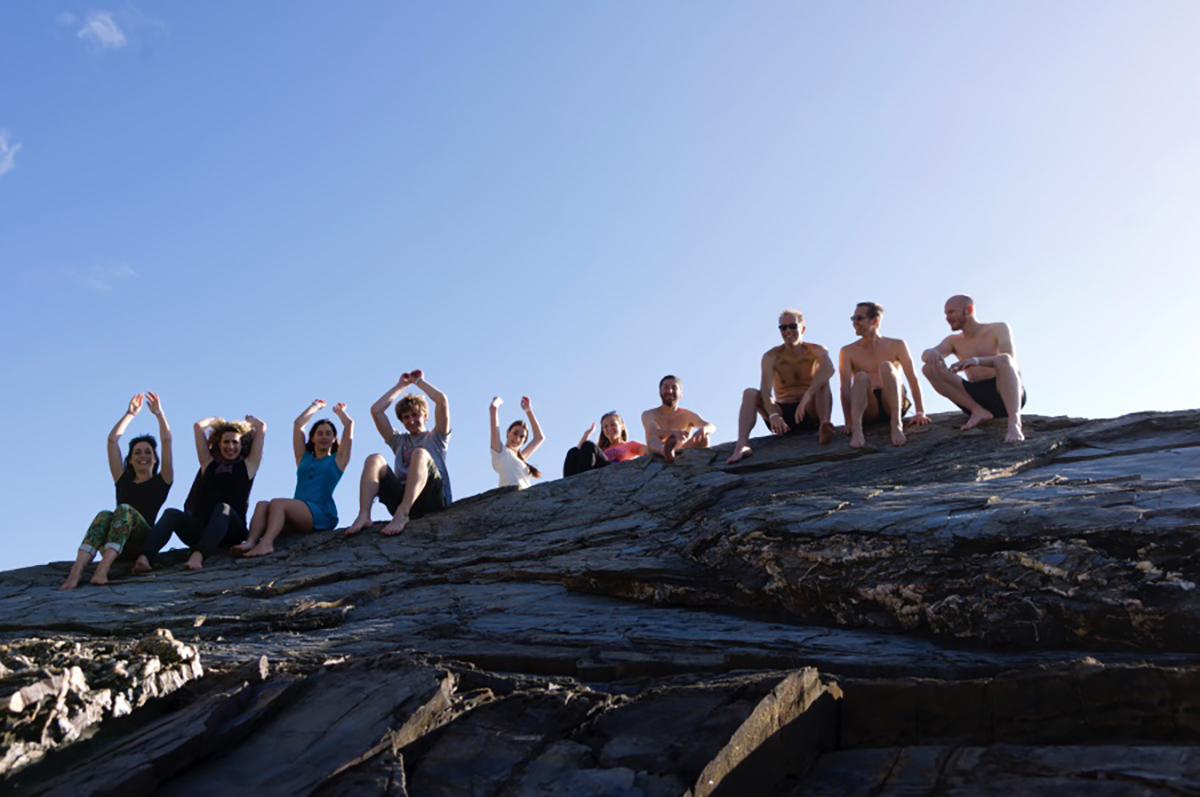 Lab group members sit on rocks 